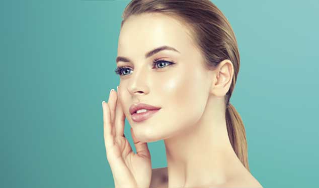 Woman in profile touching her cheek with one hand against a teal background for Sofwave ultrasound skin lifting in Dublin